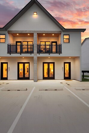 A two-story building with a balcony, large windows, and a driveway. - Kali House •  River Ranch • Prime Location • Premier Host (Lafayette)