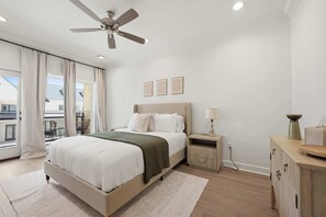 A bedroom with a bed, a nightstand, a lamp, a ceiling fan, and a view of the outside. - Kali House •  River Ranch • Prime Location • Premier Host (Lafayette)