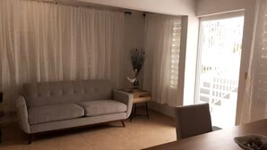 A living room with a sofa, a wooden table, and a chair. - Maricao+ Escapada Tranquila+ Privado+Self Check-in (Maricao)