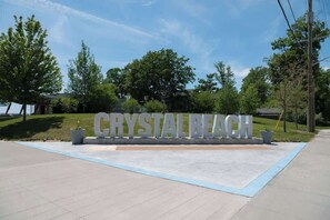 A sign reading 'CRYSTAL BEACH' with a paved area in front. - Crystal Sands Retreat - Steps to Crystal beach (Fort Erie)