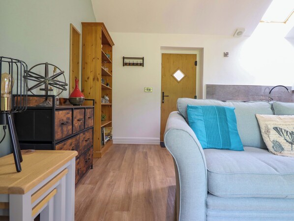 A living room with a sofa, a wooden cabinet, and a bookshelf.
