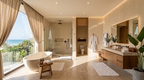 Een moderne badkamer met een vrijstaand bad, een ruime douche en een toilet.