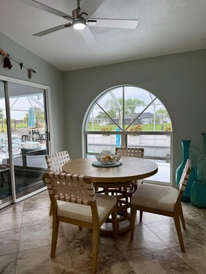 A dining area with a round table, chairs, and a ceiling fan. - Your Sebring Escape 3BR Home with Private Pool (Sebring)
