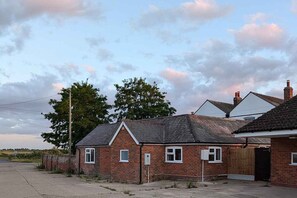 A brick house with a garage, a paved driveway, and a clear sky.