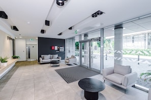 A modern lobby with a reception desk, seating area, and large windows. - Luxury 2BDR 2 Bath City Centre Manchester (Manchester)
