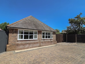 A two-story house with a brick facade, a pitched roof, and a paved driveway. - Frome View (Wareham)