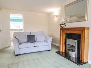 A living room with a grey sofa, a fireplace, and a mirror on the wall. - Frome View (Wareham)