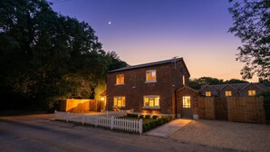 A two-story house with a brick exterior, a white picket fence, and a gravel driveway. - Hertfordshire Cottage, Designer, with Barn Suite (Wandon Green)