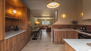 A modern kitchen with wooden cabinetry, a marble countertop, and pendant lighting. - Hertfordshire Cottage, Designer, with Barn Suite (Wandon Green)