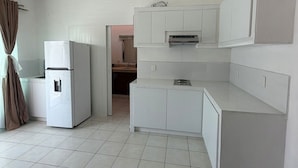 A kitchen with white cabinets, a refrigerator, and a ceiling fan. - Arroyito: Small Apartment (Puerto Vallarta)
