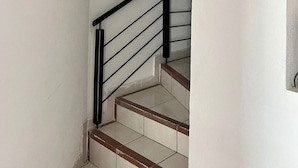 A staircase with a black metal railing and beige steps. - Arroyito: Small Apartment (Puerto Vallarta)