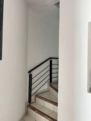 A staircase with a black metal railing and beige steps. - Arroyito: Small Apartment (Puerto Vallarta)