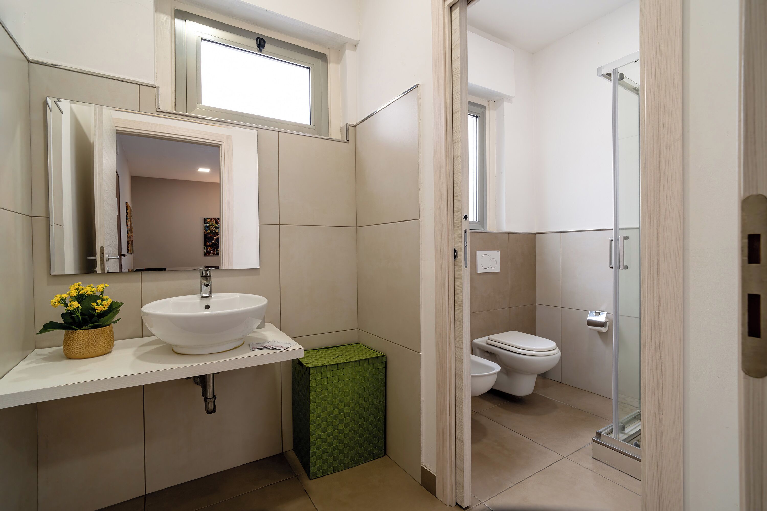 Ein Badezimmer mit Waschbecken, Spiegel, Toilette und Dusche.