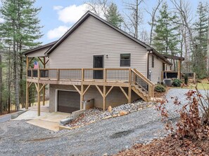 A two-story house with a covered deck and a garage. - Peaceful Mountain Retreat | Wraparound Deck (Black Mountain)