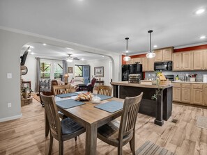 A modern kitchen with wooden cabinetry, a central island, and pendant lighting. - Peaceful Mountain Retreat | Wraparound Deck (Black Mountain)