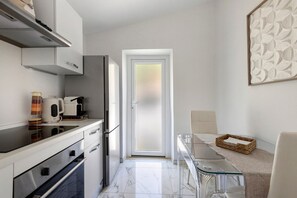 Una cuina moderna amb forn incorporat, cafetera i nevera.