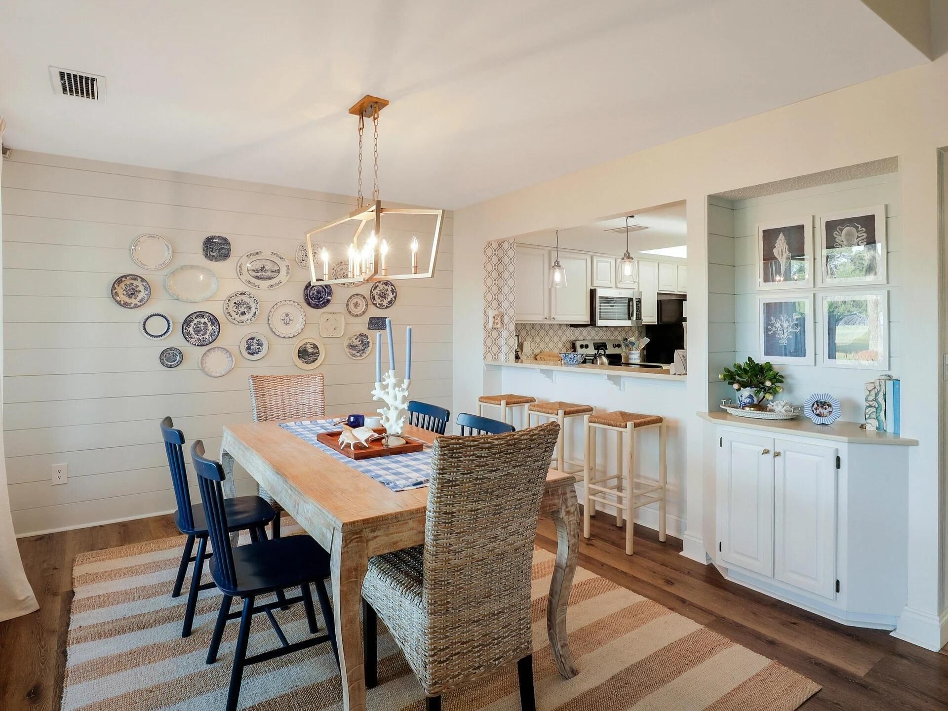 A dining area with a wooden table, blue chairs, and a hanging light fixture.