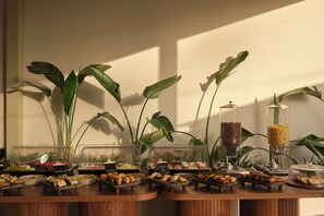 A buffet setup with various food items and a coffee dispenser. - Nerion Hotel & Spa (Chania)