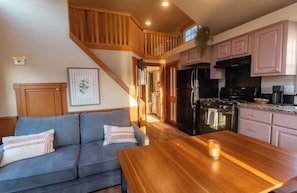 A kitchen with a refrigerator, stove, and cabinets.