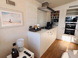 Una cocina compacta con una isla central, horno empotrado y microondas.