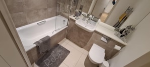 Ein Badezimmer mit einer Badewanne, einem Waschbecken, einer Toilette und einer Duschkabine.