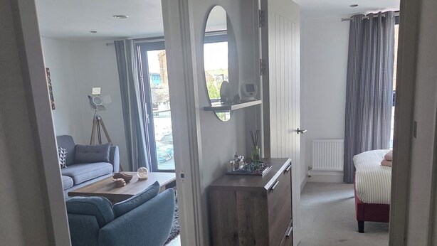 Une chambre à coucher moderne avec un grand lit, une commode et un miroir.