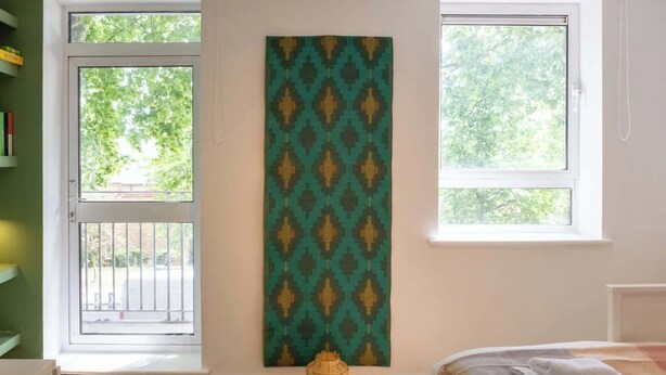 Ein Schlafzimmer mit einem Bett, einem Fenster, einer Tür und einer Wandteppich.