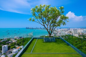 Ein Balkon mit Baum, der Blick auf den Stadtgürtel und das Meer gewährt.