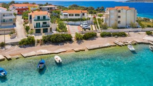 Une zone résidentielle côtière, avec des bâtiments, une eau d’un bleu limpide et des bateaux.