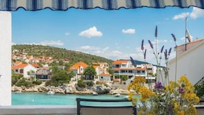 Une vue sur la côte, avec des maisons, un ciel dégagé et un balcon orné de fleurs.