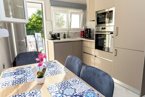 A kitchen with a microwave, oven, and coffee maker. - Aroma Zia_ Basilicum Residence_ the authentic scents, colors &  calmness of Kos (Lagoudi Zia)