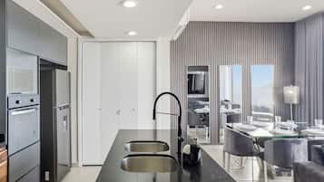 A modern kitchen with a central island, built-in appliances, and a dining area with a view.