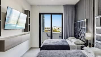 Une chambre moderne avec un lit, un téléviseur fixé au mur et un balcon offrant une vue agréable.