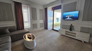 A living room with a sofa, a TV, a coffee table, and a sliding glass door leading to an outdoor area.