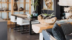 Una sala de estar moderna con una mesa de comedor de madera, un sofá y una estantería.