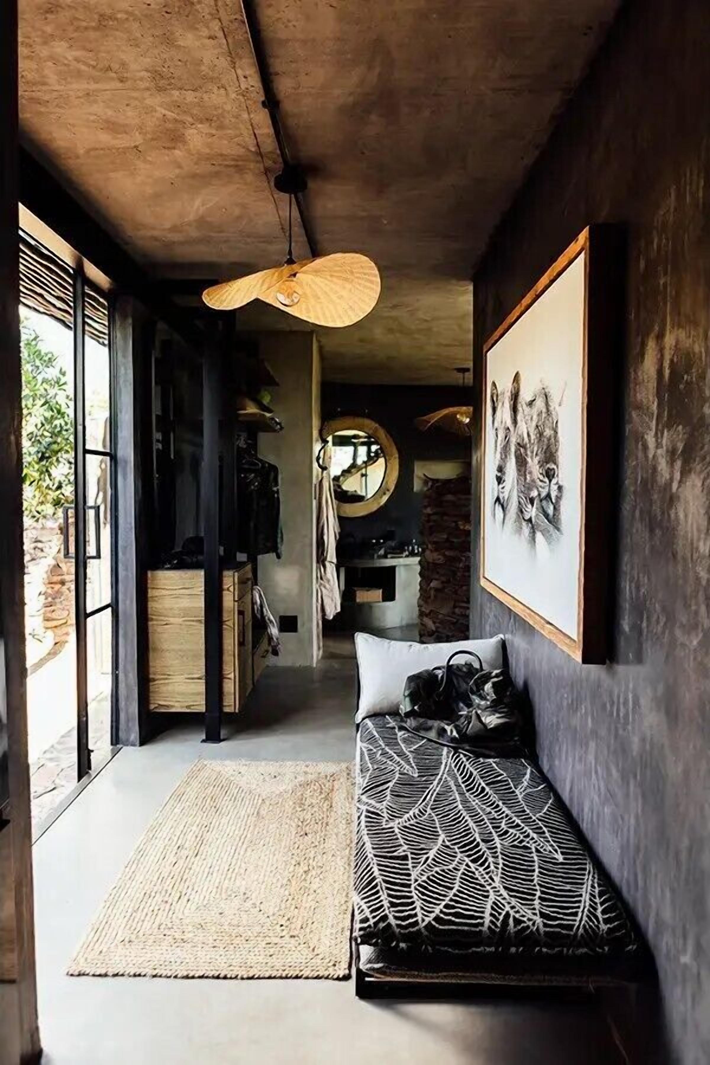A modern interior with a bench, a hanging light fixture, and artwork on the wall.