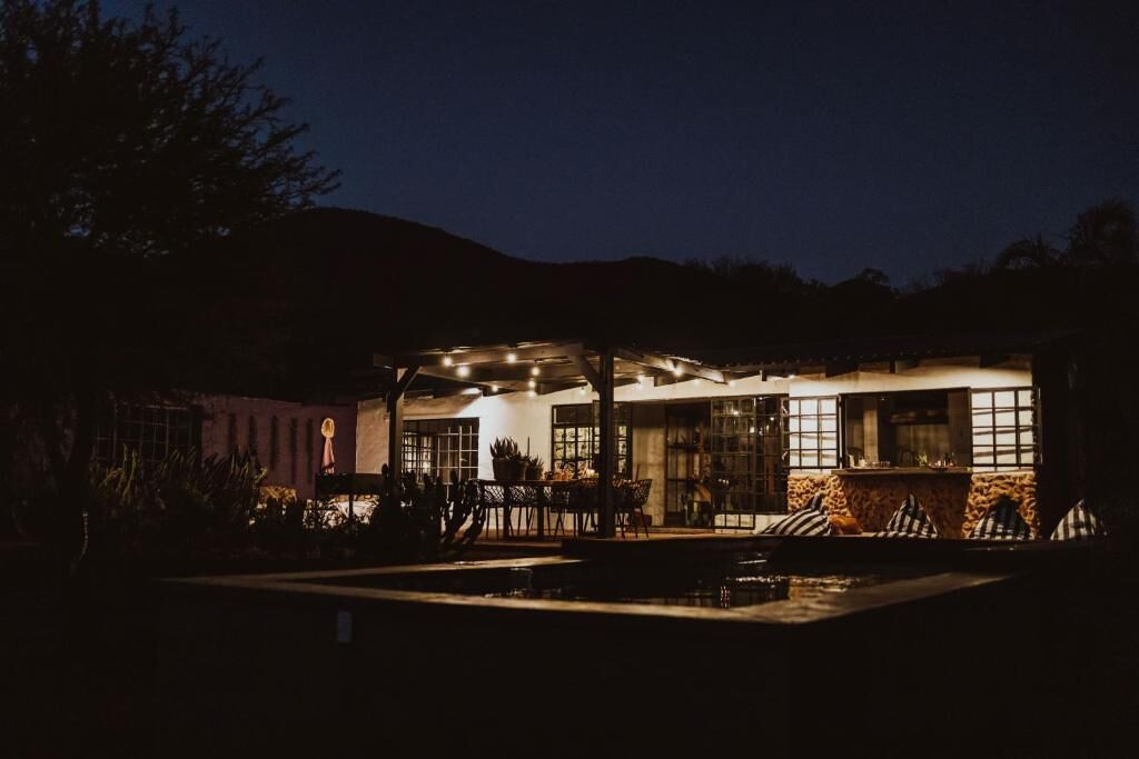 A modern building with a pool, outdoor seating, and large windows.