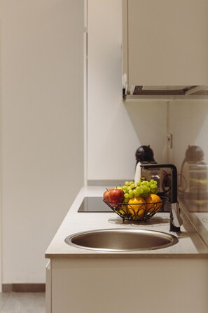 Eine Küche mit Spüle, Obstschale auf der Arbeitsfläche und Wasserkocher.