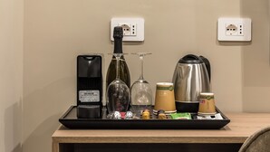 Un refrigerador compacto con puerta de vidrio, que contiene dos botellas.
