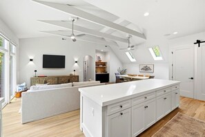 A modern kitchen with a large island, built-in cabinets, and a dining area with a long table.