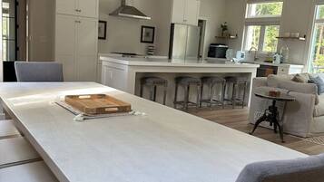 A modern kitchen with white cabinetry, a central island, and bar stools.