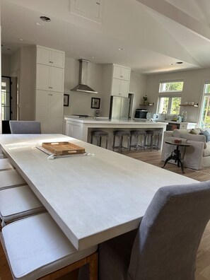 A modern kitchen with white cabinetry, a central island, and bar stools.