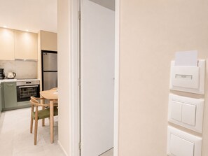 Une cuisine moderne équipée d’un réfrigérateur, d’un four et d’une table à manger avec des chaises.