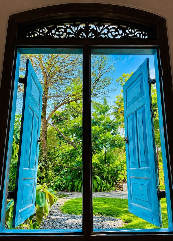 A double door with a view of a lush garden.