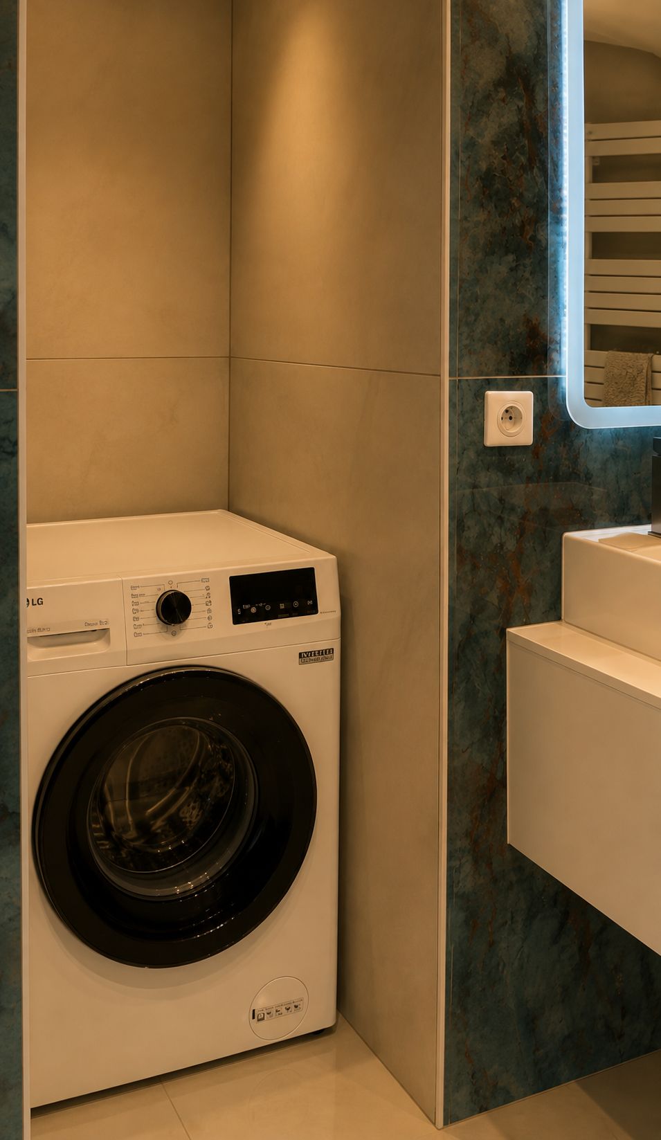 A compact, modern laundry room with a front-loading washing machine, a built-in sink, and a marble backsplash.