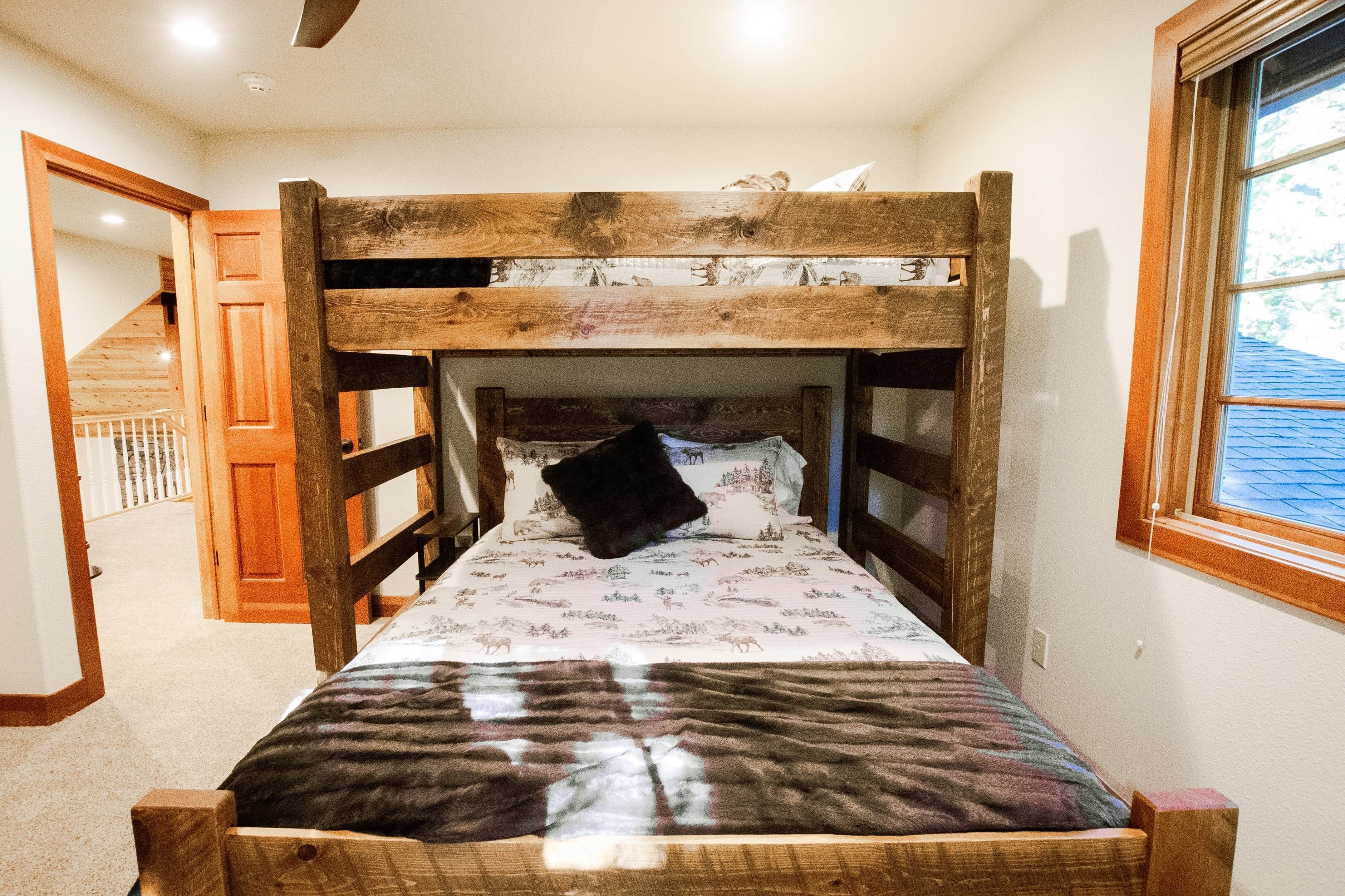 Un lit superposé avec une structure en bois et une couvre-lit à motifs.