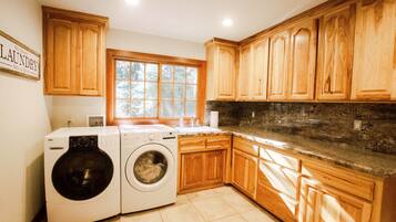 A laundry room with wooden cabinets, a washing machine, and a dryer.