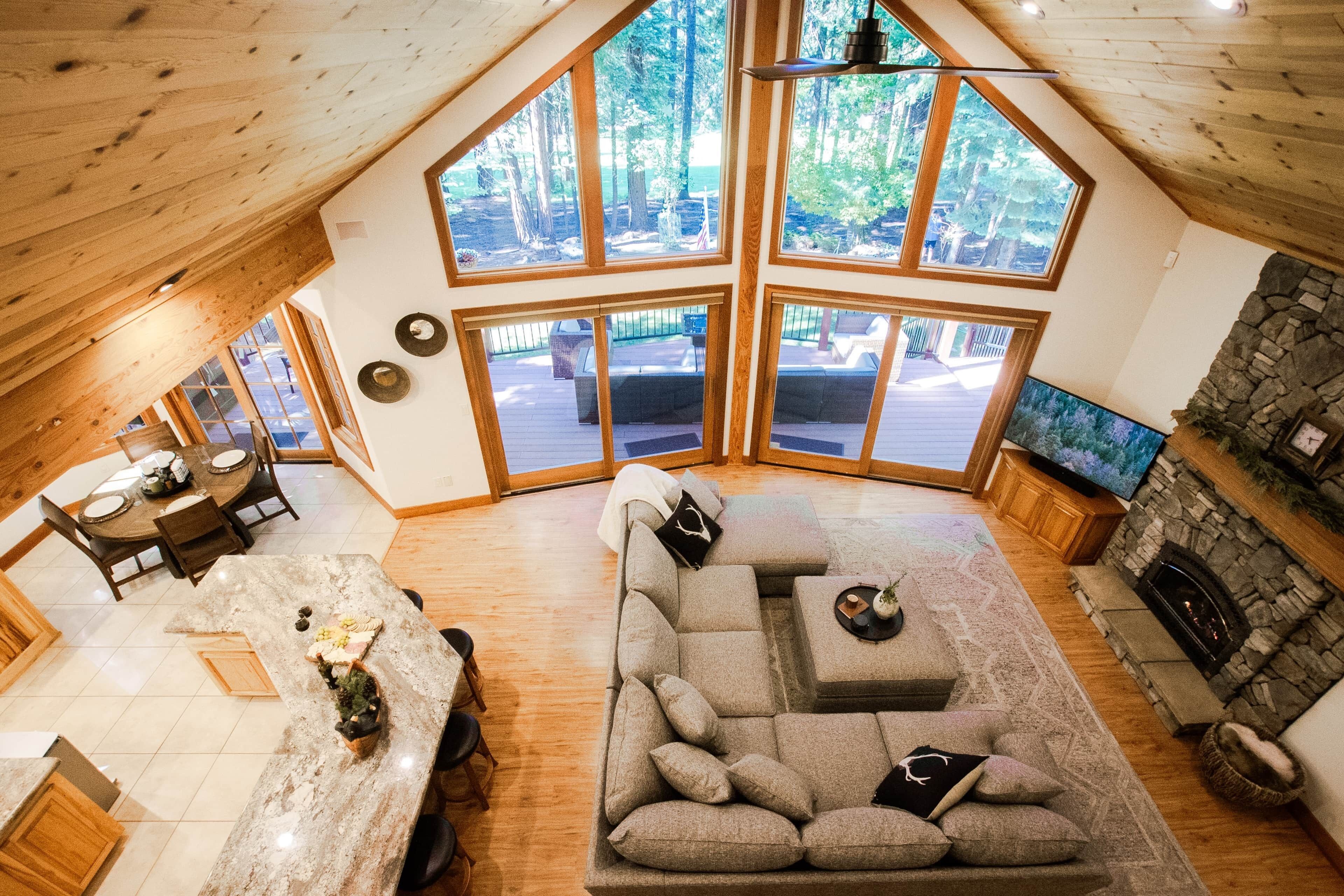 A spacious living area with a stone fireplace, a large window, and a dining area with a table set for four.