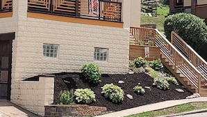 A two-story house with a balcony, a small garden, and a staircase leading to the upper floor. - Perfect 3-bedroom house in the heart of Mt. Washingston (Pittsburgh)