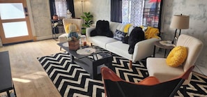 A living room with a sofa, armchair, coffee table, and a lamp. - Perfect 3-bedroom house in the heart of Mt. Washingston (Pittsburgh)